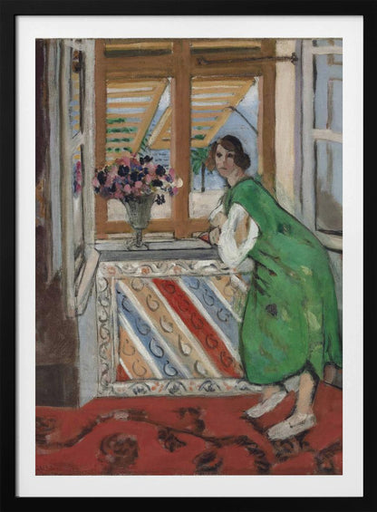 A painting by Henri Matisse depicting a woman in a loose green dress leaning on a windowsill and looking towards the viewer. Outside the open window with tan shutters, a sunny scene with a palm tree is visible. A vase of flowers sits on the sill above a colorful striped panel, and a red patterned rug covers the floor. Print