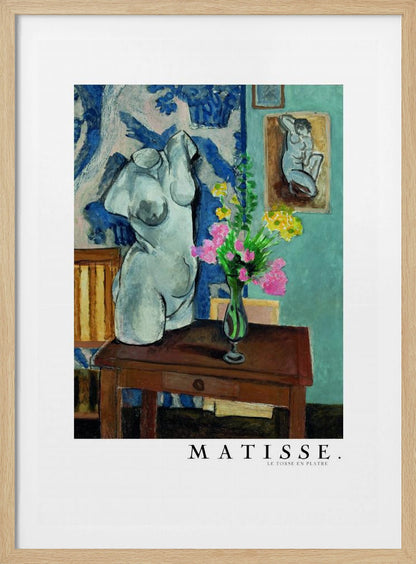 A framed art print of Henri Matisse's painting 'Le Torse en Plâtre'. The still life features a white plaster female torso sculpture next to a dark brown wooden table with a vase of pink and yellow flowers. The background consists of a blue and white patterned tapestry and a teal wall with a small framed nude drawing. Print