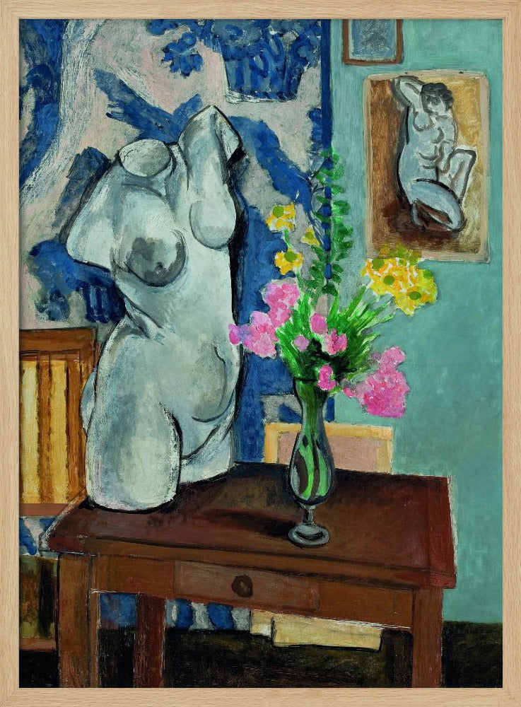 A colorful still life painting by Henri Matisse depicting a white plaster torso of a woman on a dark brown table next to a vase of bright pink and yellow flowers. The background features a blue and white patterned fabric and a light blue wall with a small framed nude drawing. Decor