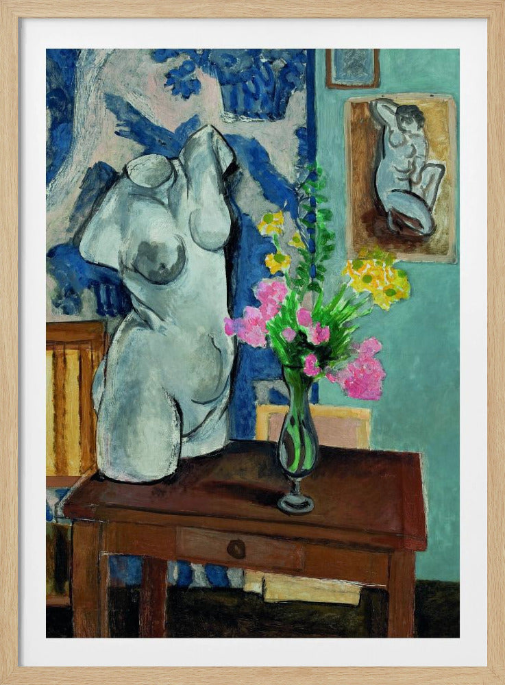 A colorful still life painting by Henri Matisse depicting a white plaster torso of a woman on a dark brown table next to a vase of bright pink and yellow flowers. The background features a blue and white patterned fabric and a light blue wall with a small framed nude drawing. Decor