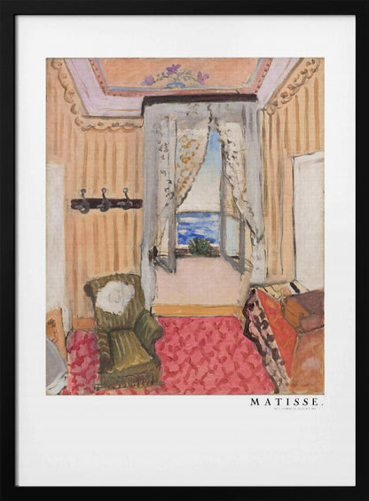 A framed print of a painting by Henri Matisse. The artwork depicts an interior room scene with peach-colored walls, a vibrant pink and red patterned rug, and an armchair. An open window with lace curtains offers a view of the blue sea. Decor