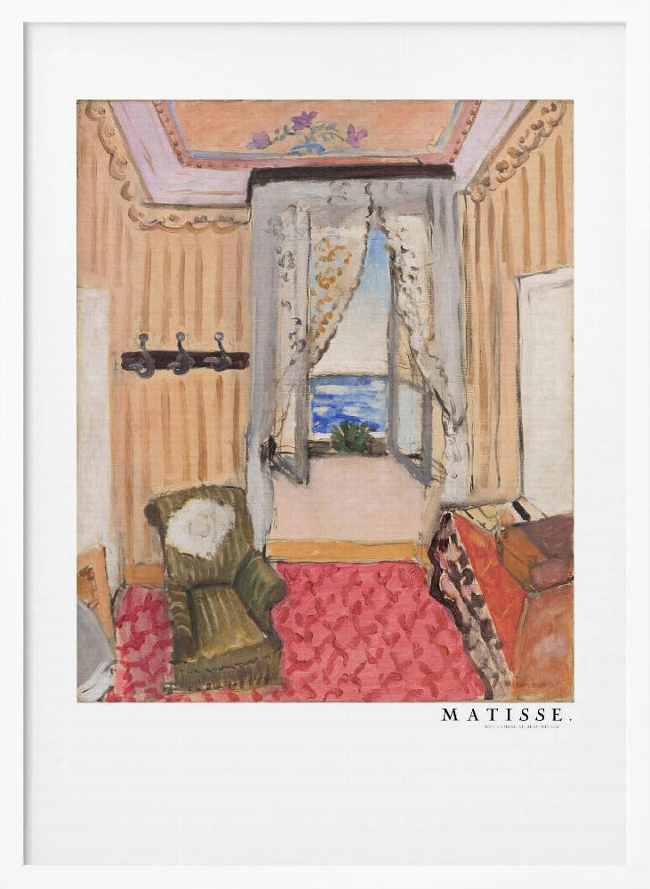 A framed print of a painting by Henri Matisse. The artwork depicts an interior room scene with peach-colored walls, a vibrant pink and red patterned rug, and an armchair. An open window with lace curtains offers a view of the blue sea. Decor