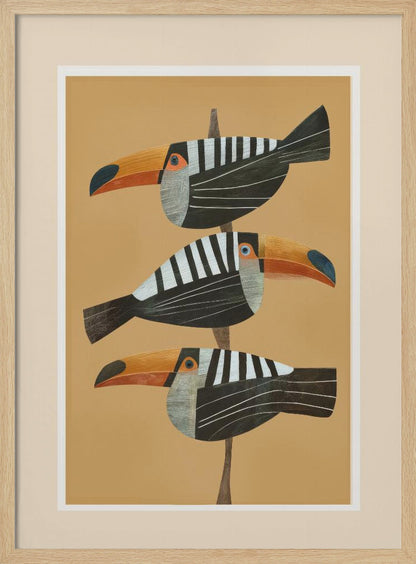 A framed graphic illustration of three stylized toucans perched one above the other on a thin vertical branch. The birds, facing left, have black bodies with bold white vertical stripes, and large, vibrant orange beaks. The background is a solid mustard yellow. Decor