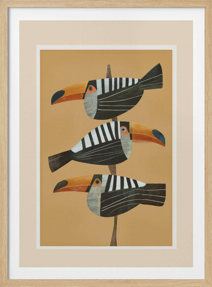 A framed graphic illustration of three stylized toucans perched one above the other on a thin vertical branch. The birds, facing left, have black bodies with bold white vertical stripes, and large, vibrant orange beaks. The background is a solid mustard yellow. Decor