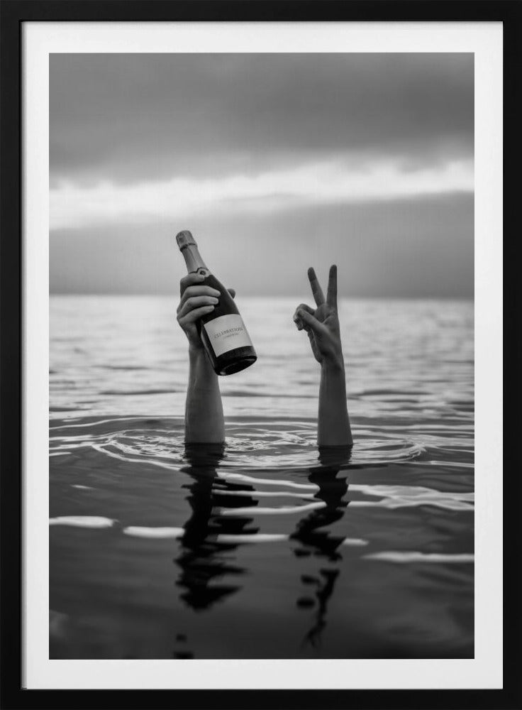 A black and white vertical photograph showing two arms sticking out of calm water. One hand holds a bottle of champagne, while the other makes a peace sign, all under a cloudy sky. Poster