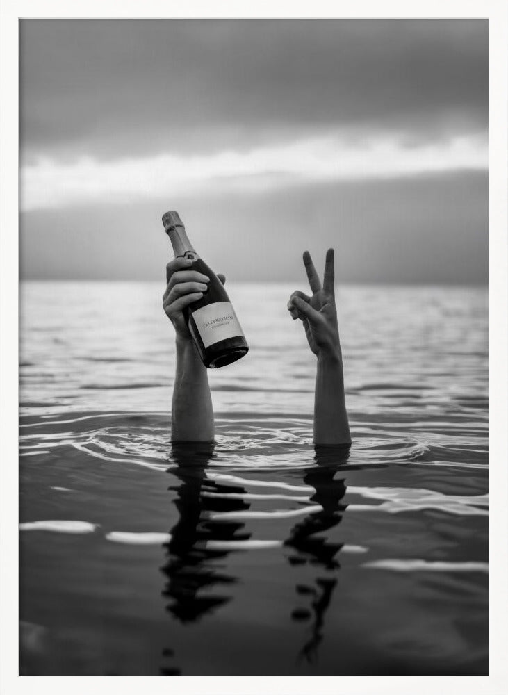 A black and white vertical photograph showing two arms sticking out of calm water. One hand holds a bottle of champagne, while the other makes a peace sign, all under a cloudy sky. Poster
