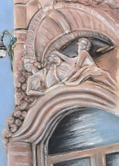 A pastel drawing of an ornate architectural detail on a building facade, featuring elaborate carvings above an arched window. The carvings depict classical female figures in flowing drapery, rendered in warm pink and brown tones against a light blue sky. A vintage-style street lamp is visible to the left. Wall Art