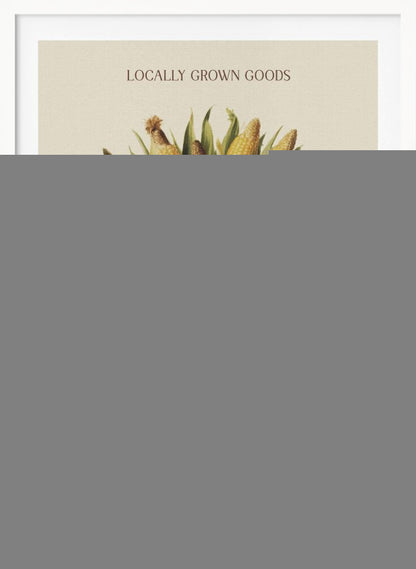 A vintage-style art print with a black frame featuring a wicker basket full of ears of corn. The poster has text that reads 'LOCALLY GROWN GOODS' at the top and 'FARMERS MARKET AUTUMN CORN COLLECTION' at the bottom. The background is a light cream color. Artwork