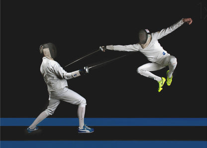 A dynamic action shot of two fencers in full white gear and masks dueling with foils against a stark black background. The fencer on the right is captured mid-air in a dramatic leap, while the fencer on the left lunges forward on a surface marked with blue lines. The image is enclosed in a silver frame. Artwork
