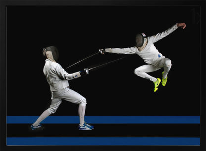 A dynamic action shot of two fencers in full white gear and masks dueling with foils against a stark black background. The fencer on the right is captured mid-air in a dramatic leap, while the fencer on the left lunges forward on a surface marked with blue lines. The image is enclosed in a silver frame. Artwork