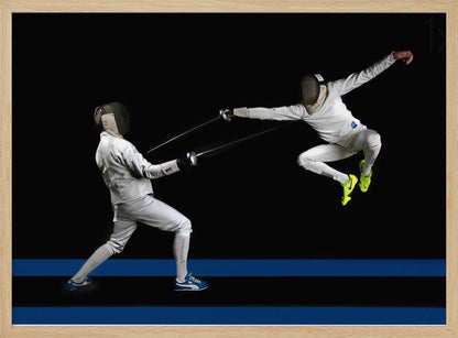 A dynamic action shot of two fencers in full white gear and masks dueling with foils against a stark black background. The fencer on the right is captured mid-air in a dramatic leap, while the fencer on the left lunges forward on a surface marked with blue lines. The image is enclosed in a silver frame. Artwork