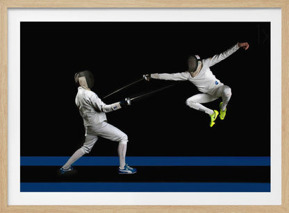A dynamic action shot of two fencers in full white gear and masks dueling with foils against a stark black background. The fencer on the right is captured mid-air in a dramatic leap, while the fencer on the left lunges forward on a surface marked with blue lines. The image is enclosed in a silver frame. Artwork