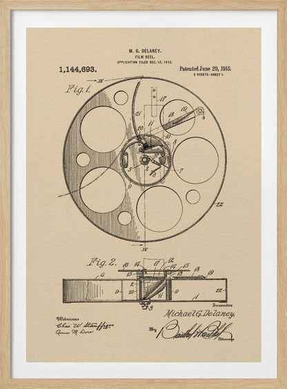 A framed vintage patent illustration of a film reel from 1915 by M.G. Delaney. The drawing is in black ink on a beige background, showing detailed schematics of the reel's mechanics from two different angles, complete with numbered parts, signatures, and patent information. Wall Art