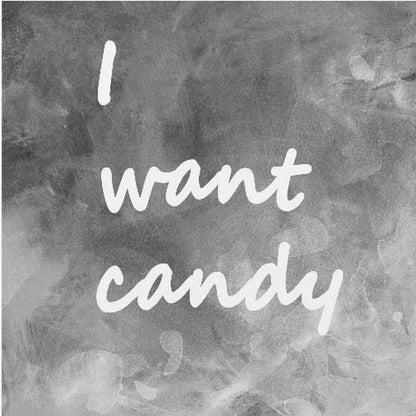 A framed typography art piece with a light brown wood frame. It features the phrase 'I want candy' in a white, handwritten script against a textured, dark gray and white chalkboard-style background. Wall Art