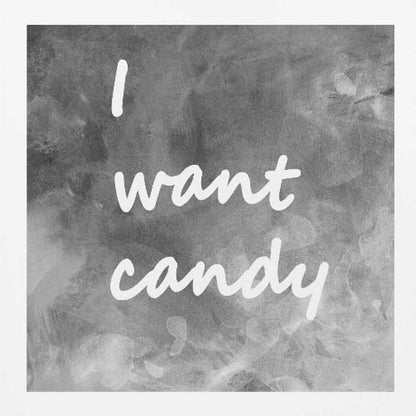 A framed typography art piece with a light brown wood frame. It features the phrase 'I want candy' in a white, handwritten script against a textured, dark gray and white chalkboard-style background. Wall Art