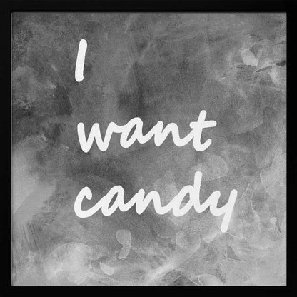 A framed typography art piece with a light brown wood frame. It features the phrase 'I want candy' in a white, handwritten script against a textured, dark gray and white chalkboard-style background. Wall Art