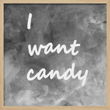 A framed typography art piece with a light brown wood frame. It features the phrase 'I want candy' in a white, handwritten script against a textured, dark gray and white chalkboard-style background. Wall Art