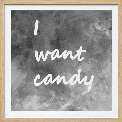 A framed typography art piece with a light brown wood frame. It features the phrase 'I want candy' in a white, handwritten script against a textured, dark gray and white chalkboard-style background. Wall Art