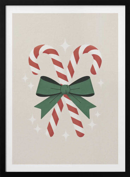 An illustration of two red-and-white striped candy canes crossed and tied together with a large green bow. The background is a soft beige color with small, white, four-pointed star sparkles. The artwork is shown in a black frame. Decor