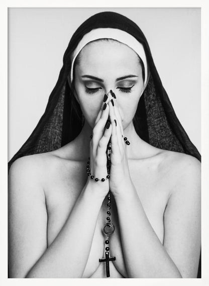 A black and white portrait of a woman with dramatic eye makeup wearing a nun's habit. Her eyes are closed and her hands are clasped in front of her face in prayer, holding a black rosary. Her shoulders are bare, creating a stark contrast. Artwork
