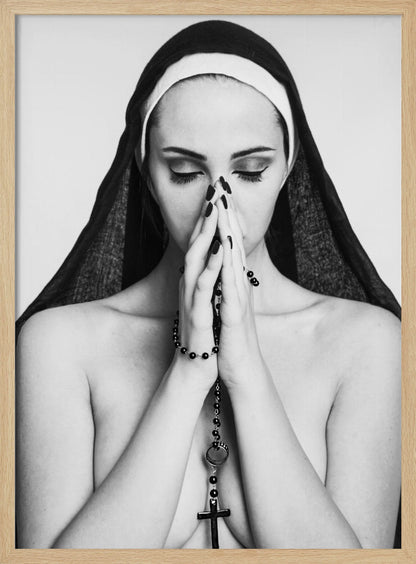 A black and white portrait of a woman with dramatic eye makeup wearing a nun's habit. Her eyes are closed and her hands are clasped in front of her face in prayer, holding a black rosary. Her shoulders are bare, creating a stark contrast. Artwork