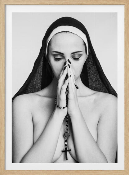 A black and white portrait of a woman with dramatic eye makeup wearing a nun's habit. Her eyes are closed and her hands are clasped in front of her face in prayer, holding a black rosary. Her shoulders are bare, creating a stark contrast. Artwork