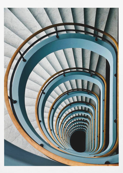 A high-angle, top-down photograph of a multi-story rectangular spiral staircase, creating a hypnotic, receding pattern. The steps are light gray marble, contrasted by shadows, and the balustrade is a striking light blue with a warm wooden handrail, leading down to a dark abyss at the center. Wall Art