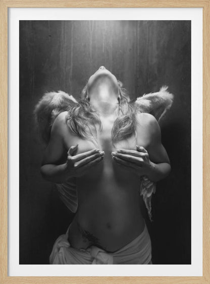 A dramatic black and white photograph of a topless woman with angel wings, her head tilted back towards a light from above. She is covering her breasts with her hands, and a white cloth is draped around her hips. Poster