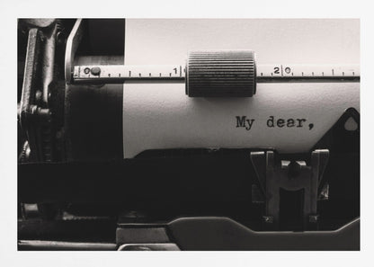 A close-up, black and white photograph of a vintage typewriter. A sheet of white paper is loaded, and the words 'My dear,' have just been typed, creating a sense of nostalgia and romance. The image is enclosed in a silver frame. Wall Art