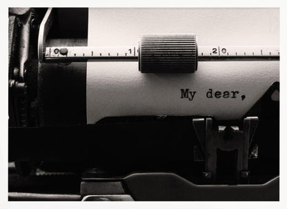 A close-up, black and white photograph of a vintage typewriter. A sheet of white paper is loaded, and the words 'My dear,' have just been typed, creating a sense of nostalgia and romance. The image is enclosed in a silver frame. Wall Art