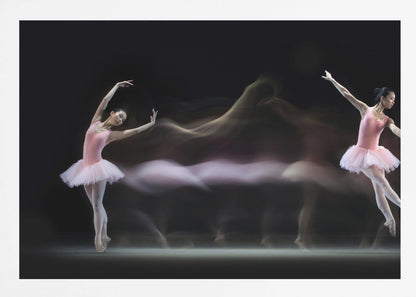 A long-exposure photograph capturing the fluid motion of a ballerina in a pink leotard and tutu. Two clear poses of the dancer frame a central, ethereal blur of movement against a dark, solid background, all encased in a silver frame. Artwork