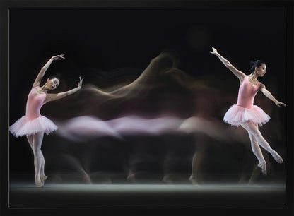 A long-exposure photograph capturing the fluid motion of a ballerina in a pink leotard and tutu. Two clear poses of the dancer frame a central, ethereal blur of movement against a dark, solid background, all encased in a silver frame. Artwork