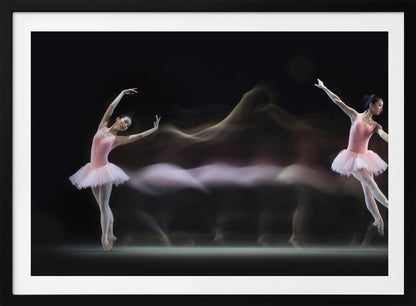 A long-exposure photograph capturing the fluid motion of a ballerina in a pink leotard and tutu. Two clear poses of the dancer frame a central, ethereal blur of movement against a dark, solid background, all encased in a silver frame. Artwork