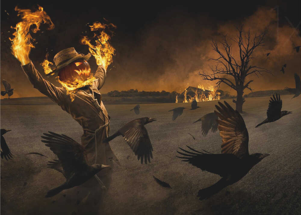 A terrifying scarecrow with a glowing jack-o'-lantern for a head stands in a dark field, its hands engulfed in flames raised towards the sky. A flock of black crows flies around it in a frenzy, while in the background, a barn burns under a dark, smoky orange sky. Wall Art