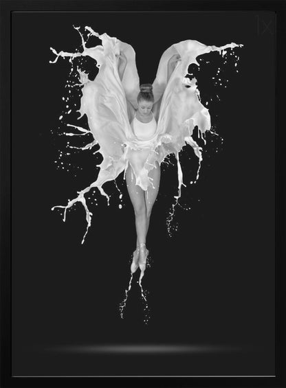 A dramatic black and white photograph of a ballerina suspended in mid-air against a black background. She is en pointe, and a dynamic splash of white liquid surrounds her, creating the illusion of wings. Artwork