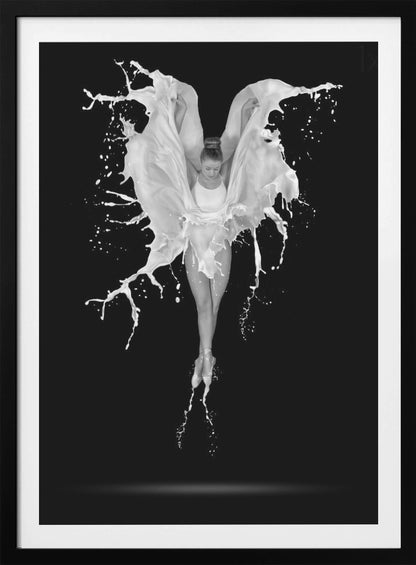 A dramatic black and white photograph of a ballerina suspended in mid-air against a black background. She is en pointe, and a dynamic splash of white liquid surrounds her, creating the illusion of wings. Artwork