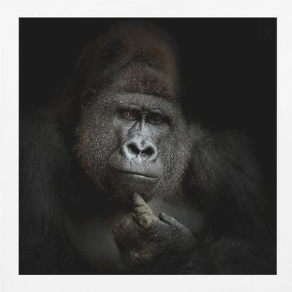 A dramatic, framed portrait of a gorilla against a black background. The gorilla looks directly at the viewer with a thoughtful expression, its chin resting on its hand. Decor