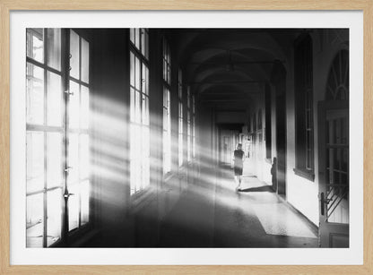 A black and white photograph of a woman walking away down a long, dark hallway. Bright shafts of sunlight pour through large windows on the left, creating a dramatic interplay of light and shadow on the floor and walls. Poster
