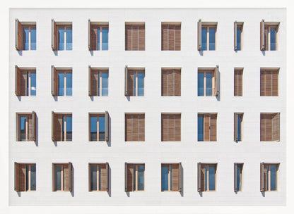 A symmetrical architectural photo of a modern white building facade featuring a grid of twenty-eight windows with wooden louvered shutters, some open and some closed, creating a varied pattern, all within a brushed silver frame. Decor