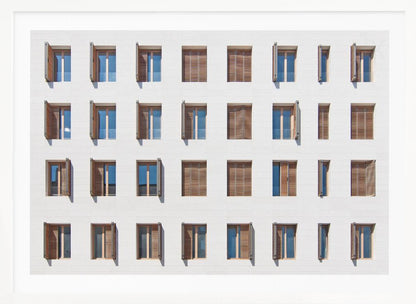 A symmetrical architectural photo of a modern white building facade featuring a grid of twenty-eight windows with wooden louvered shutters, some open and some closed, creating a varied pattern, all within a brushed silver frame. Decor