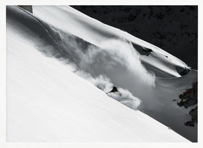 A dramatic black and white photograph of a skier speeding down a steep, snow-covered mountain, kicking up a large cloud of powder. The image is framed with a brushed silver border. Decor