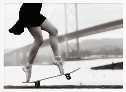 A black and white photograph of a ballerina's legs in a black dress, balancing en pointe on a skateboard with a blurred bridge in the background. Artwork