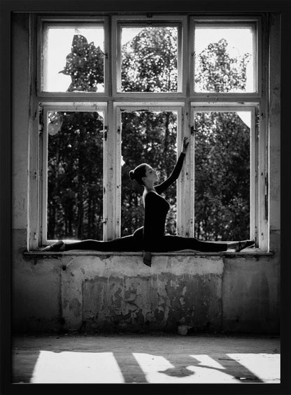 A black and white photograph of a graceful female dancer holding a perfect split on a large, dilapidated windowsill. She is silhouetted against the bright light from the broken window panes, with her arm elegantly raised. The setting is an abandoned room with peeling paint, creating a stark contrast between the dancer's elegance and the decaying environment. Wall Art