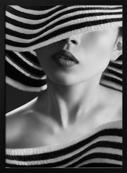 A mysterious black and white close-up portrait of a woman wearing a large, floppy hat with bold black and white stripes. The hat's brim covers her eyes, revealing only her nose, full lips, and chin, creating an elegant and enigmatic look. Decor