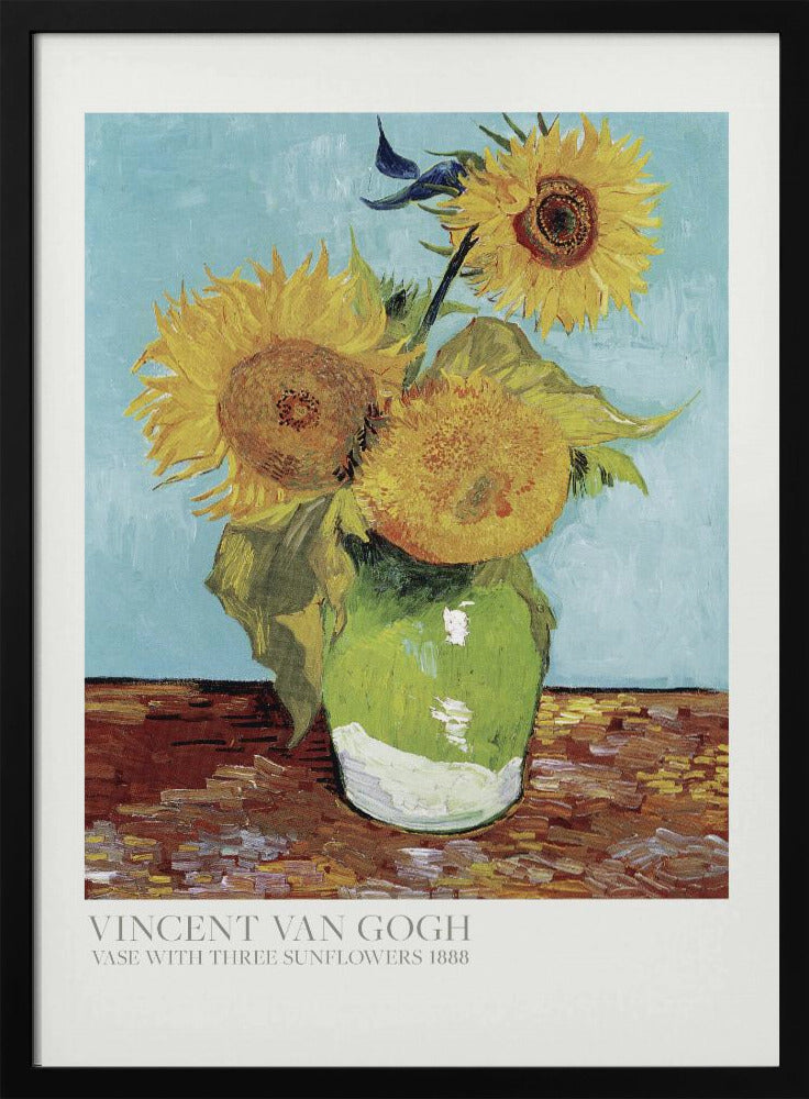 A framed art print of Vincent van Gogh's painting 'Vase with Three Sunflowers' from 1888. The artwork features three large, vibrant yellow sunflowers in a green vase set against a textured light blue background. The painting is in the post-impressionist style with thick, visible brushstrokes. The print has a white border with text at the bottom identifying the artist and title. Print