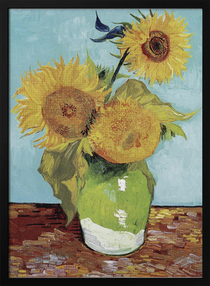 A framed reproduction of Vincent van Gogh's famous 'Sunflowers' painting, featuring three large yellow sunflowers in a green vase against a light blue background, painted in his iconic post-impressionist style with thick brushstrokes. Wall Art