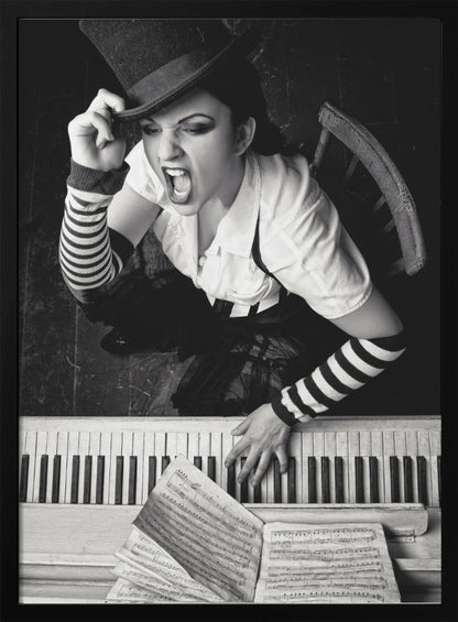 A dramatic black and white high-angle photograph of a woman in a top hat and striped arm warmers, shouting or singing passionately while seated at a piano with sheet music. Print