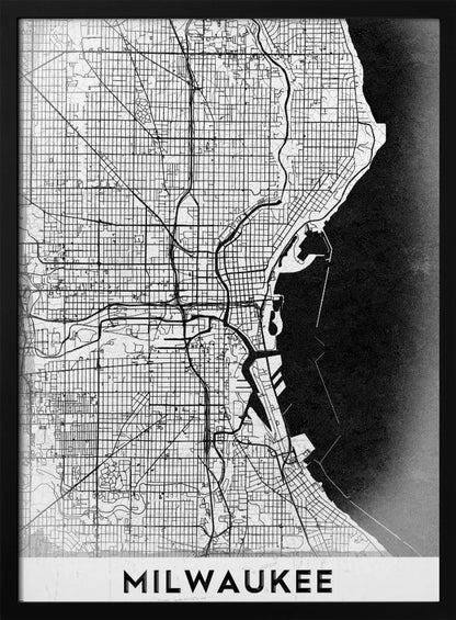 A minimalist, black and white street map of Milwaukee, displayed in a black frame. The map details the city's grid system, major roads, and waterways against a textured background, with the word 'MILWAUKEE' in a bold, sans-serif font at the bottom. Poster