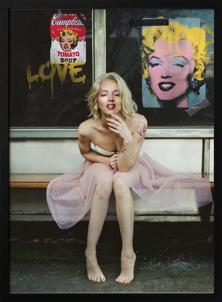 A blonde woman styled like Marilyn Monroe sits on a bench, wearing a pink tulle skirt. Behind her, a dark window features an Andy Warhol-style poster of Monroe, a Campbell's soup can parody, and the word 'LOVE' in gold graffiti. Artwork