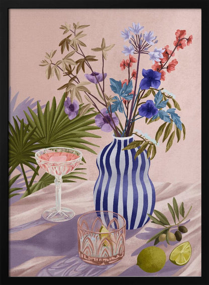 A vibrant still life painting featuring a blue and white striped wavy vase filled with a colorful bouquet of flowers. To the left is a pink cocktail in a coupe glass and a decorative tumbler. In the foreground, there are fresh limes and an olive branch. The scene is set on a draped pink cloth against a soft pink background with shadows from palm leaves. Artwork